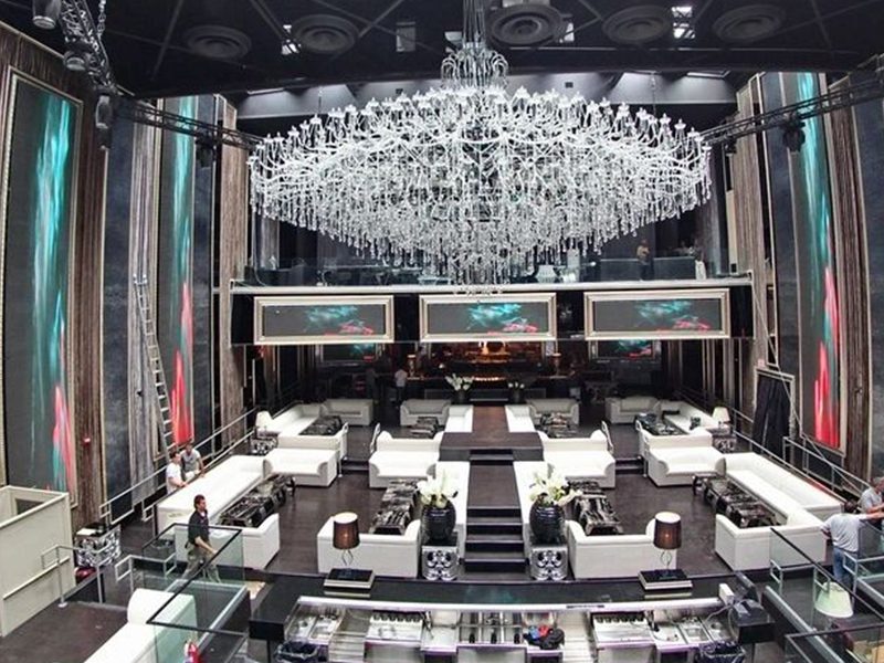 Nightclub interior with large crystal chandelier and white banquette seating