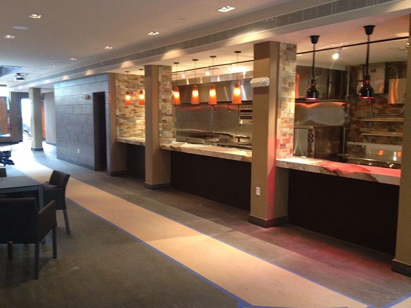 Open kitchen with stone columns, heat lamps and stone counters