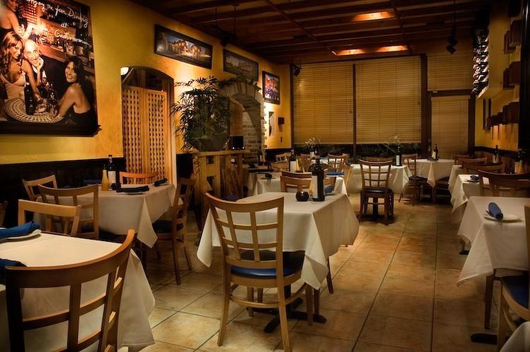 Italian restaurant dining room with set tables and warm lighting