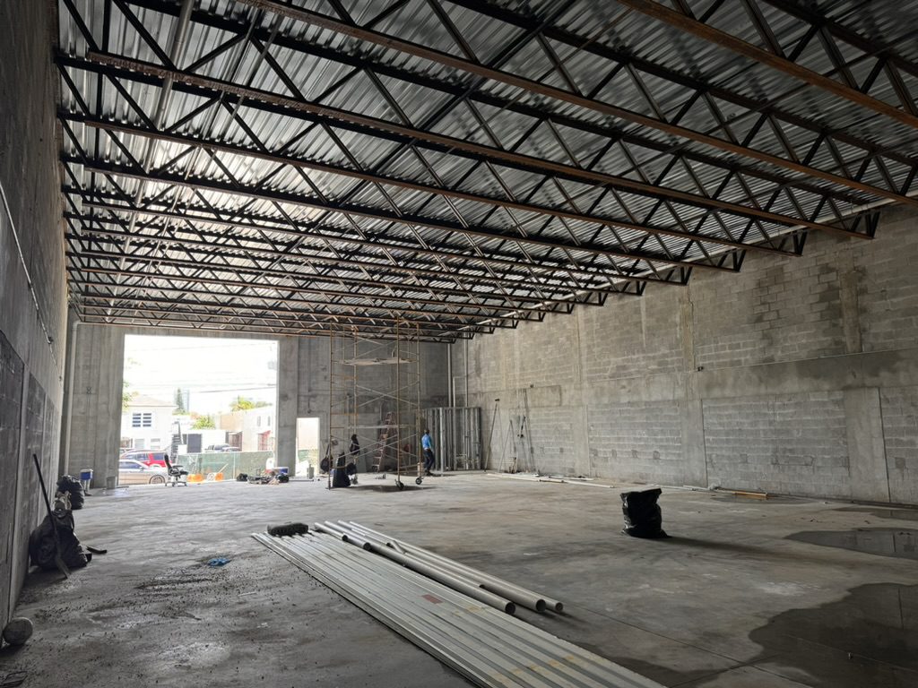 Interior of a completed shell with steel deck roof overhead and finished slab