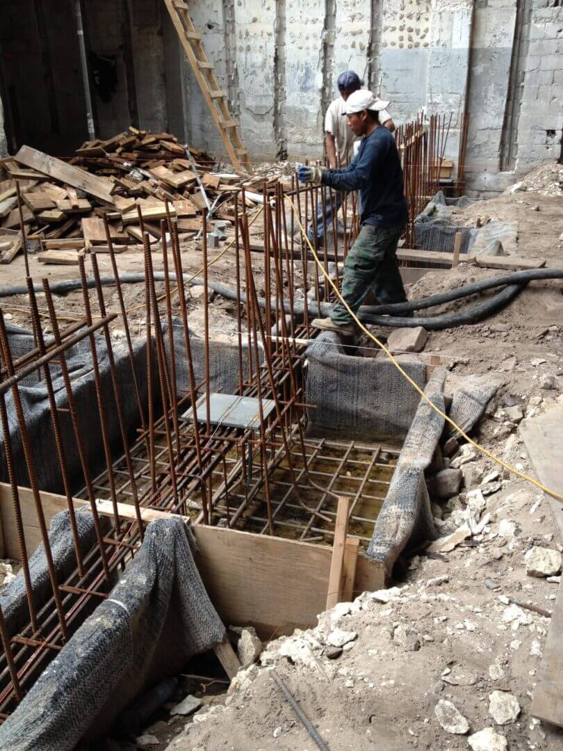 Rebar cages and formwork for new footings inside a gutted structure