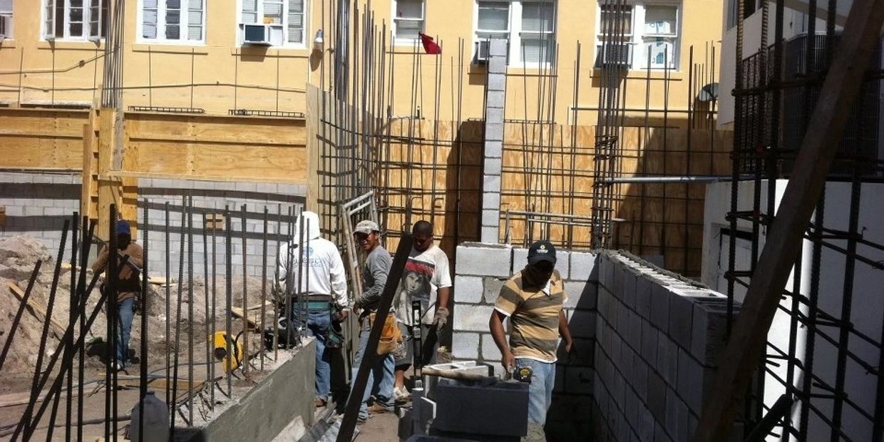 A group of men working on the side of a building.