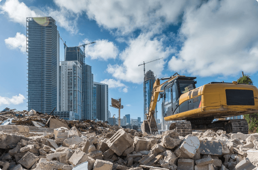 A bulldozer is on the rubble of a construction site.