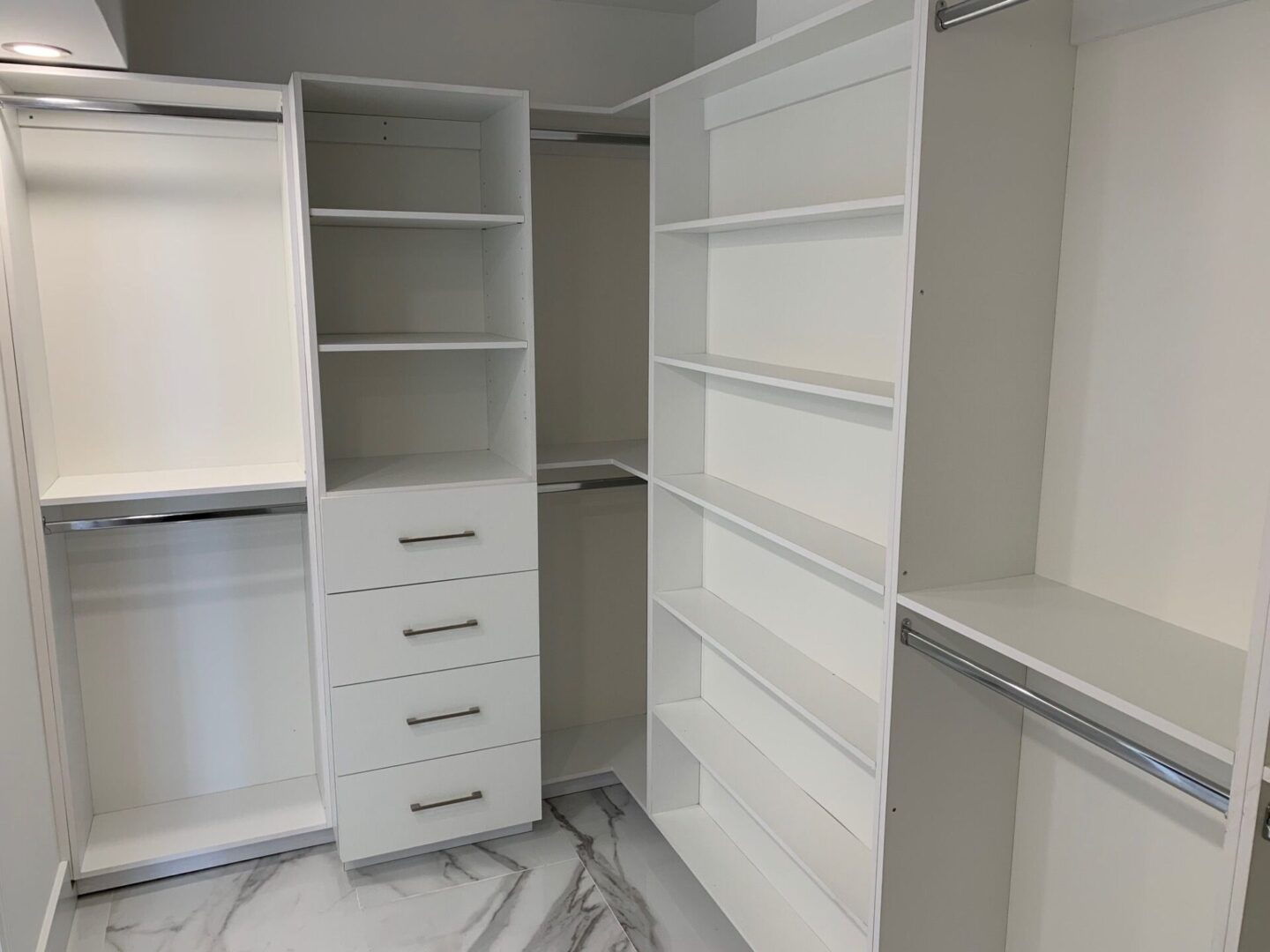A white closet with shelves and drawers in it