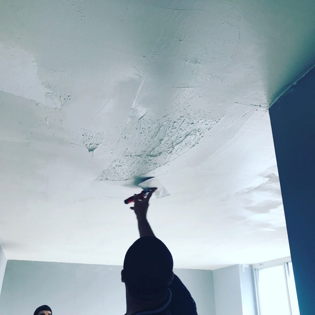 A person is holding something up to the ceiling.